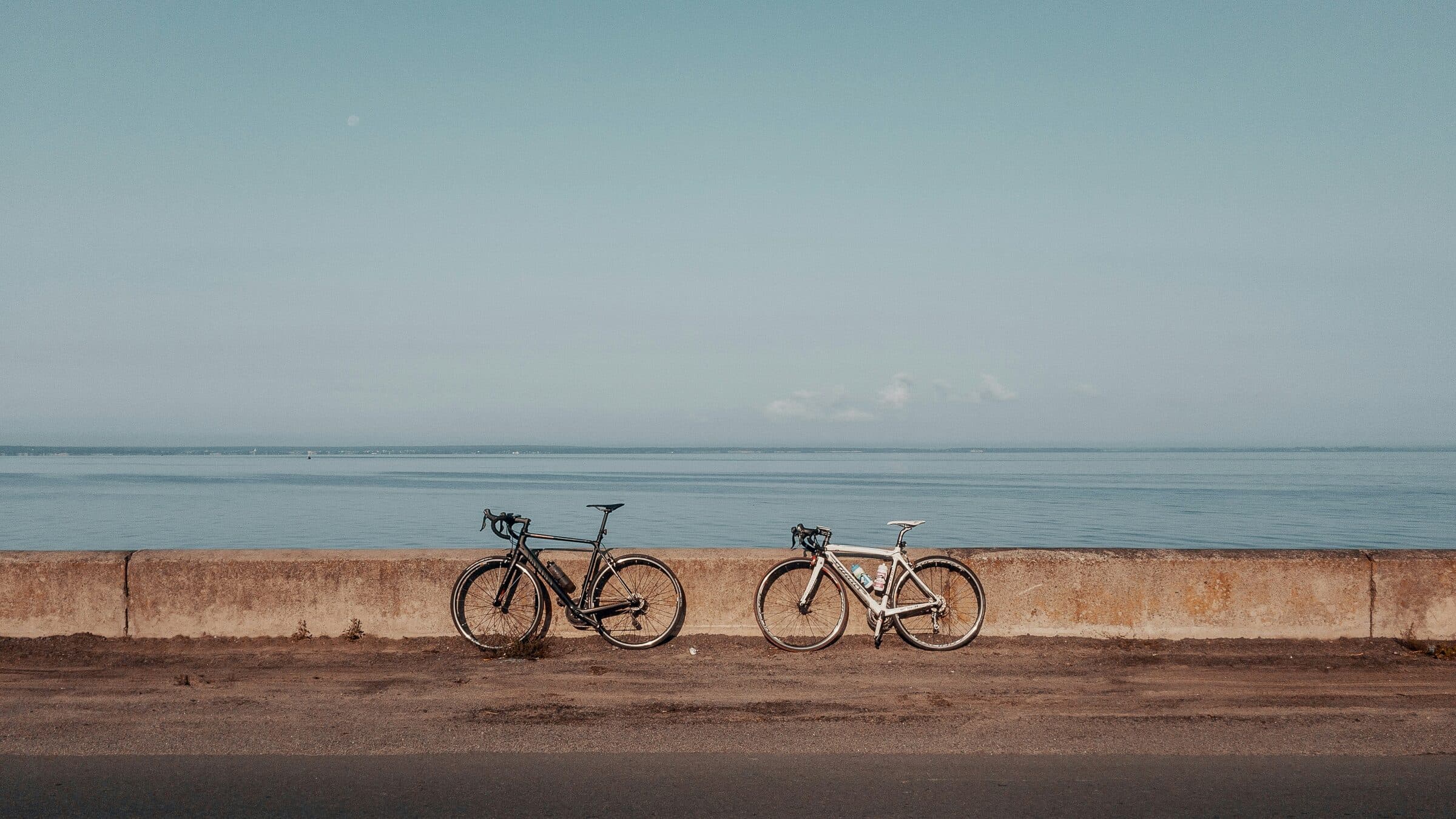 Two bicycles resting by the seafront